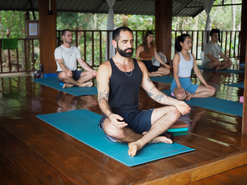 Student meditating as part of a daily 200-hour yoga teacher training routine